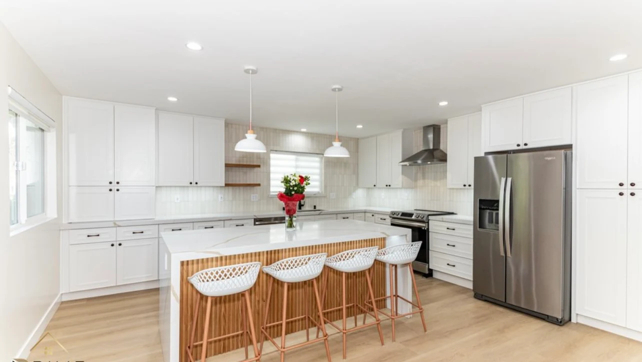 Bright white kitchen with wood island and pendant lighting — Simply Stunning Kitchens Los Angeles